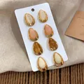Vue macro de boucles d'oreilles clous en acrylique en forme de goutte sur carte - Tige en Argent-Couleurs Mixtes