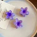 Gros plan de mini pinces à cheveux en acrylique violettes en forme de fleur sur une assiette - Lot de 3 / Violet foncé