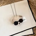 Nahaufnahme eines Plüschbären-Anhängers mit schwarzer Sonnenbrille an einer Kugelkette - Silber-Braun-Schwarz Halskette