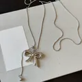 Close-up of a silver bow pendant on a delicate snake chain with adjustable slider. - Silver