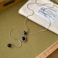 Vue détaillée d'un pendentif hexagramme en argent avec une perle noire sur une chaîne serpent. - Argent-Noir