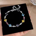 Close-up of a vibrant colorful geometric zircon bracelet resting on a black velvet display pad. - Silver - Rainbow