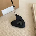 Gros plan d'un pendentif en forme de cœur en cuir noir avec un fermoir en métal argenté - Pendentif Suspendu au Cou / Noir