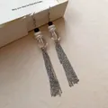 Gros plan d'élégantes boucles d'oreilles pendantes argentées avec perles - Crochets de boucles d'oreilles / Argent