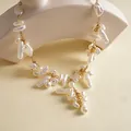 Detailansicht unregelmäßiger Barockperlen an einer goldenen Quastenkette im Vintage-Stil - Halskette-Weiß-Kurz