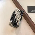 Detailopname van een elegante meerlaagse armband met zwarte kralen en strasstenen. - Zilver-Zwart