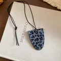 Detailansicht eines grauen Brillenclips mit Leopardenmuster und schwarzer Kordel - Halskette / Grau-Kaffee Leopard