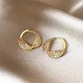 Close-up detail of luxury 14k gold-plated twisted hoop earrings with pavé zirconia - Twisted Hoop / Gold