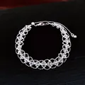 Detailansicht eines silbernen Perlenarmbands mit Kristallakzenten auf dunklem Stoff - Armband - Silber / Transparent