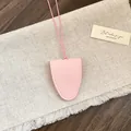 Detail van roze lederen brilhouder hanger met getextureerde afwerking en koord - Roze