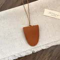 Detailopname van een bruine leren brillenclipketting met zeer fijne stiksels - Bruin