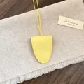 Detailweergave van een heldergele leren brillenhouder hanger op een linnen achtergrond - Geel