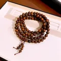 Detailed view of layered wooden beaded bracelet with natural grain and knotted tassel. - Four-layer Wrap Style / 8mm Bead Diameter / Brown