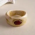 Vue détaillée d'un bracelet en résine vintage avec motif marbré et métal doré - Rouge et Beige