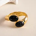 Vue détaillée d'un bracelet jonc doré avec pierres ovales en résine noire marbrée, style vintage. - Noir