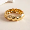 Vue détaillée d'un bracelet jonc doré épais avec une texture plissée irrégulière brillante - Or