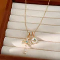 Macro view of a 18k gold plated necklace featuring star and cross pendants with zircons - Gold