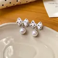 Gedetailleerde weergave van zoete polkadot strik oorbellen met witte parels - Stippen Strik Parel Stijl / Wit