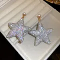 Elegant sparkling star drop earrings with iridescent rhinestones in a velvet jewelry box - Gold AB Color