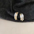 Detailaufnahme der unregelmäßigen wellenförmigen C-förmigen Ohrringe mit Emaille-Finish. - Gold und Silber Zweifarbiger Mix / Silberstift Emaille Stil / Silber