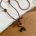 Close-up detail of a vintage wooden bear pendant with a cute bow on a soft brown cord. - Bear (2#)