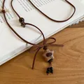 Detail view of a retro wooden star necklace featuring a bear face and a brown bow - Star (4#)
