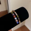 Close-up of 18k gold plated open bangle with colorful square zircons on black display. - 18K Gold Plated Luxury Multicolor Bangle (HB7004)