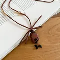 Close-up detail of a vintage wooden bear pendant necklace on an open book surface - Bear (4#)