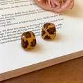 Dettaglio di orecchini vintage a cuore in resina con stampa leopardata ambra - Quadrato / Marrone