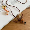 Detailed view of the cute wooden bear pendant and beaded accents on a retro brown cord necklace - Puppy (1#)