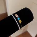 Detail of 18k gold plated bangle with colorful gemstones and clear zircon tennis bracelet. - 18K Gold Plated Multicolor Bangle (HB7004)
