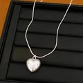 Detail view of a silver heart pendant necklace with polka dots on a jewelry display tray - Heart Pendant / Silver
