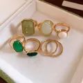 Set di 7 anelli color oro con pietre in resina verde e crema di varie forme. - Set da 7 pezzi / Oro-Verde