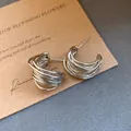 Detail von silbernen C-förmigen Creolen mit einzigartigem mehrsträngigem Design. - Mehrlagige Gedrehte C-Förmige Ohrstecker / Hellkaffeegold