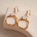 Dettaglio degli orecchini vintage a cerchi dorati con elegante intarsio in resina bianca - Stile a Gancio / Oro con Bianco