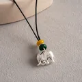 Gros plan d'un pendentif éléphant ethnique avec des perles colorées sur cordon en cuir - Pendentif Éléphant