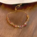 Bracciale dorato regolabile con pietre di zircone colorate su fondo in legno - Oro-Multicolore
