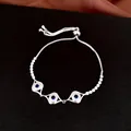 Vue détaillée d'un bracelet coulissant œil protecteur argenté avec zircons bleus étincelants - Argent Rond / Cordon Réglable