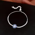 Vue détaillée d'un bracelet bolo mauvais œil argenté avec des zircons bleus et blancs. - Bleu Argenté / Cordon Réglable