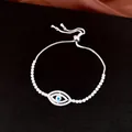 Gros plan d'un bracelet œil porte-bonheur en zircone étincelante avec fermoir coulissant - Mauvais Œil Argent / Cordon Réglable