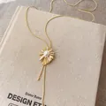 Vintage 18k gold-plated necklace with pearl sunburst pendant on textured linen book - Sunburst Pendant Style (HN13585) / Gold-Silver