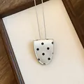 Gedetailleerde weergave van de vintage zilveren polkadot lederen brillenclip ketting voor dames - Brilhouder Ketting / Zilveren Stippen