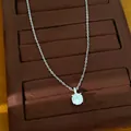 Gedetailleerde macrofoto van een zilveren ketting met een ronde zirkonia-hanger. - Ketting / Zilver-Wit