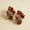 Macro-weergave van vintage bladvormige oorbellen met amberkleurige glasstenen en steentjes - Oorknopjes (Zilveren Stift) / Bruin / Goud