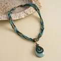 Gedetailleerd macro-aanzicht van vintage druppelketting met blauwe hars en strass - Gouden Blauwe Druppel Stijl