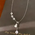 Detailed view of the hollow 'Fu' charms and shell gourd pendant on a silver necklace - Gourd Pendant / Silver-Blue