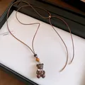 Dettaglio di una collana con ciondolo a forma di orso in resina marrone e cordino - Collana / Argento-Caffè