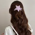 Detailed shot of a pink star-shaped acetate hair claw clip with black polka dots. - Silver Star / Pink Polka Dot