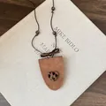 Close-up detail of brown triangular glasses holder necklace with leopard heart charm - Heart / Brown