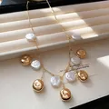 Nahaufnahme einer Quastenhalskette mit Perlen und goldenen Perlen auf einem Tablett - Halskette / Gold-Weiß